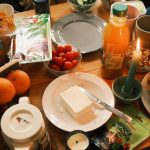 A cozy breakfast spread featuring fresh fruits, bread, and juice, surrounded by warm candlelight.